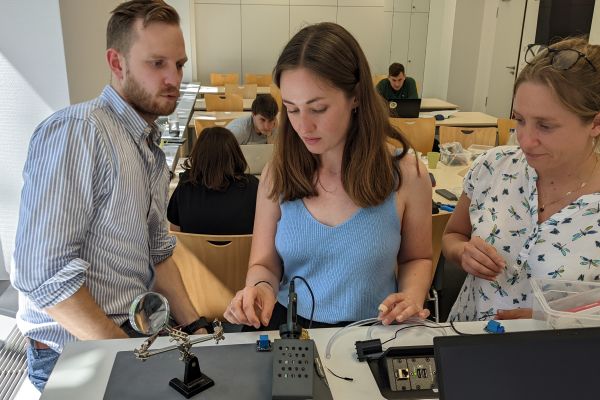 Jugendliche und Lehrkraft forschen im Klassenzimmer mit Notebooks und Elektronik 01