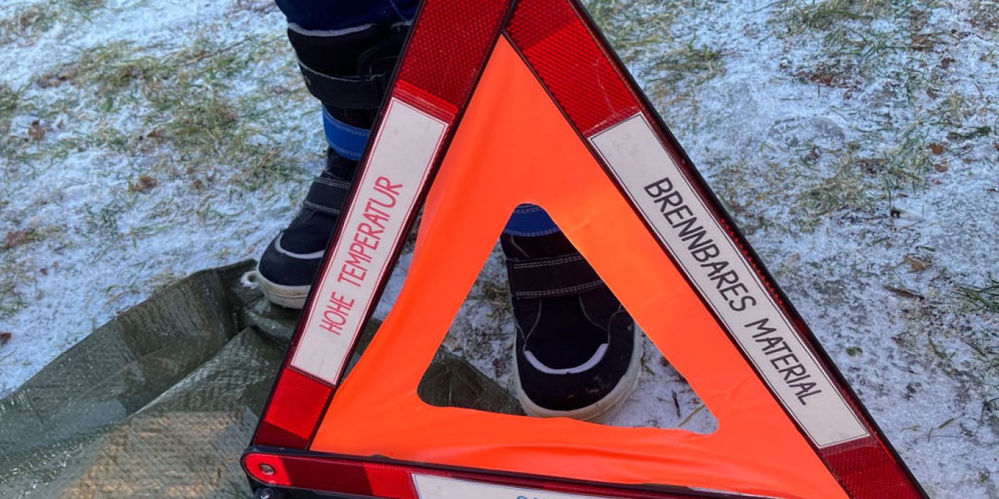 Aufgebautes Warndreieck als Symbol für Vorsicht Feuer